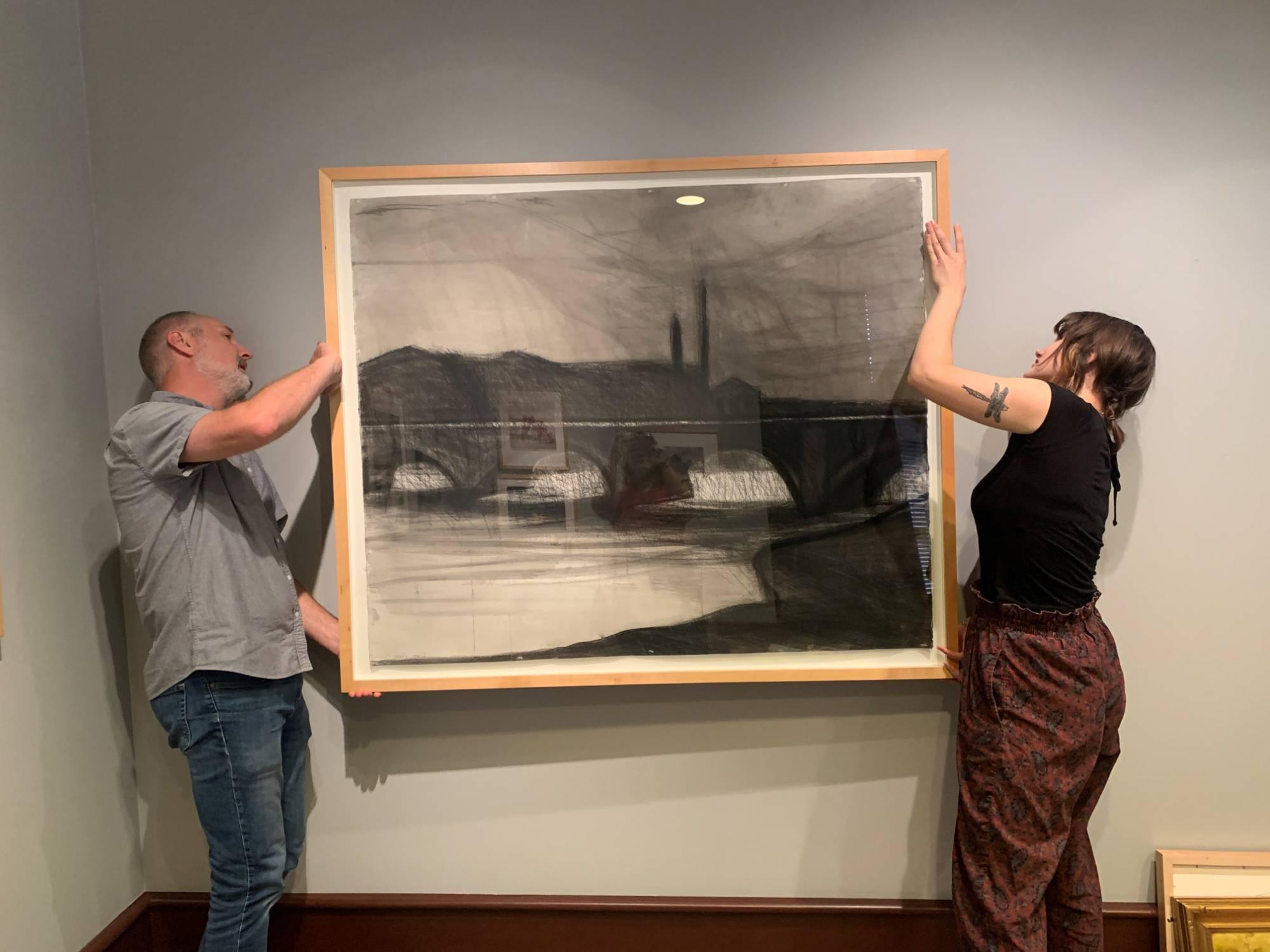 art gallery team installing artwork in hallway